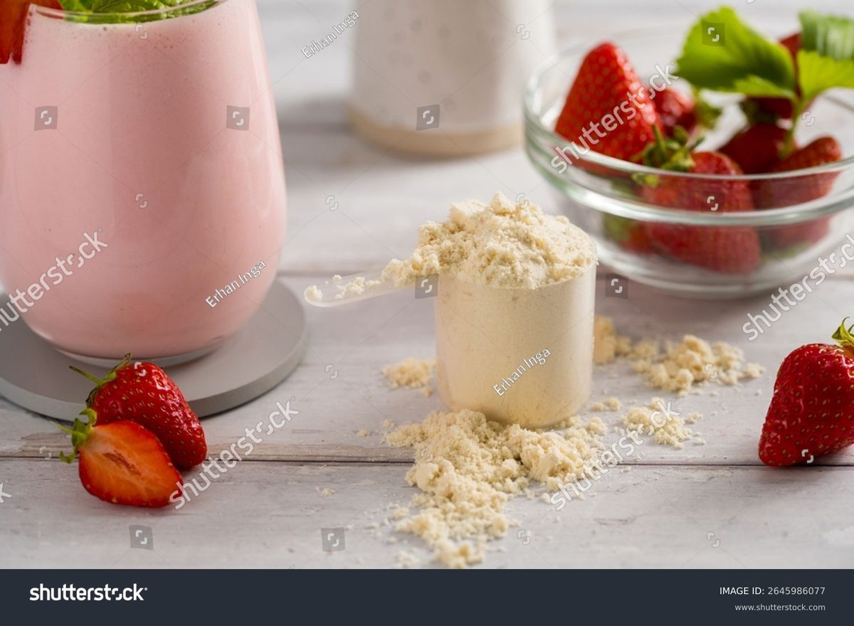 A scoop of plant protein powder with fresh strawberries and a smoothie